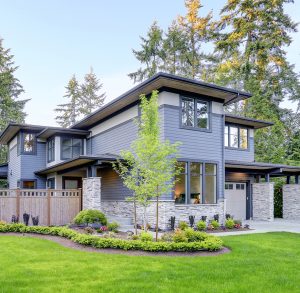 Gray two-story contemporary home with stone accents and new landscaping