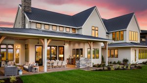 White farmhouse with a covered patio and outdoor dining at sunset